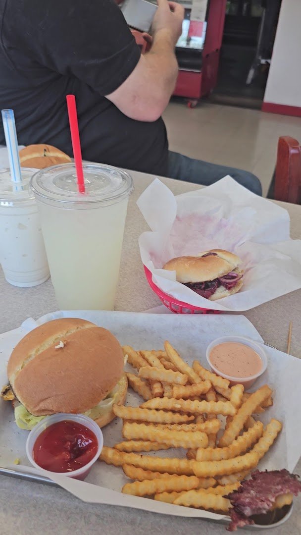Burger plates and shakes on a diner table.