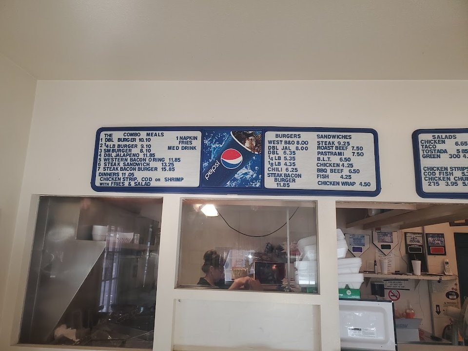 Menu board with burgers, salads, and shakes.