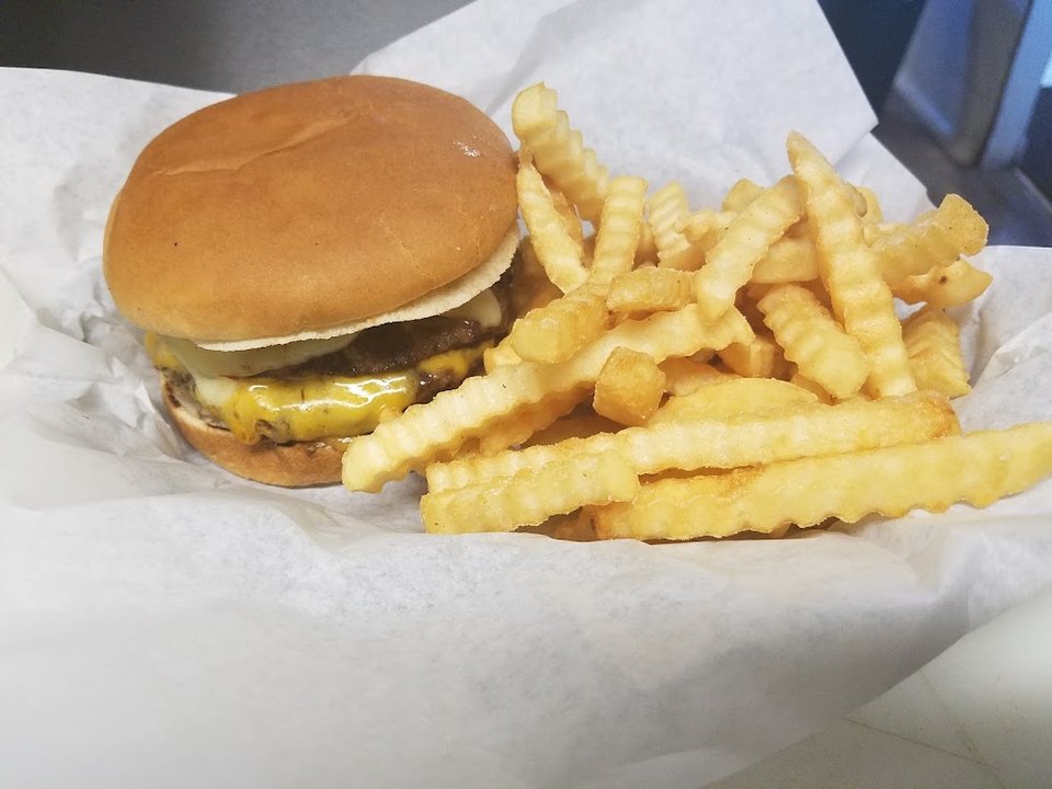 Menu board with burgers, salads, and shakes.