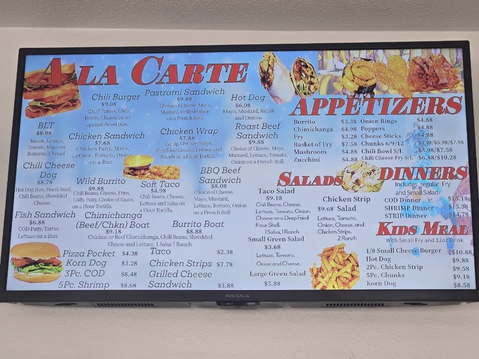 Menu board with burgers, salads, and shakes.
